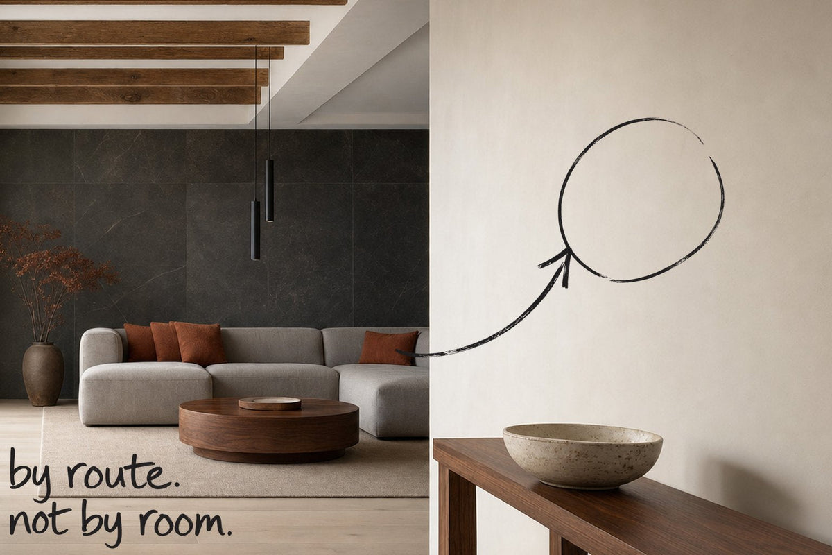 An entrance hall with a dark stone wall and a slim console table, the wall on the route to the table circled in open black marker, an arrow from the handwritten words by route, not by room, by Willem van der Krieken