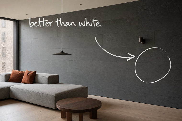 A living room with a dark honed stone wall along its length and a stone grey sofa, the dark stone wall circled in open black marker, an arrow from the handwritten words better than white, by Willem van der Krieken