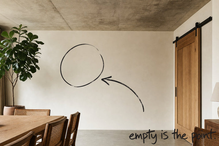 A dining room with a concrete ceiling and a steel-framed window, the wall to one side of the empty space circled in open black marker, an arrow from the handwritten words empty is the point, by Willem van der Krieken