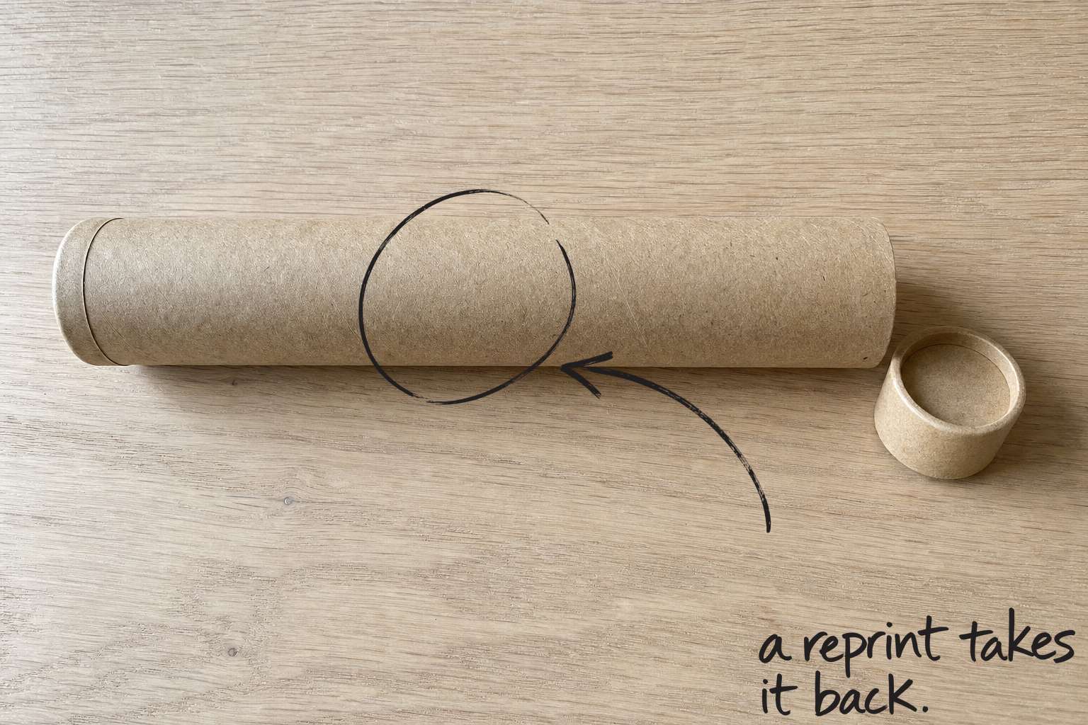 A plain cardboard postal tube lying on an oak tabletop, the postal tube circled in open black marker, an arrow from the handwritten words a reprint takes it back, by Willem van der Krieken
