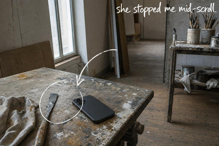 A mobile phone lying face down on a paint-stained studio table, the phone lying face down circled in open black marker, an arrow from the handwritten words she stopped me mid-scroll, by Willem van der Krieken